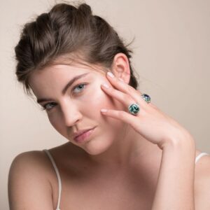 Model wearing a LEYSER blue-green tourmaline and diamond ring beside her face