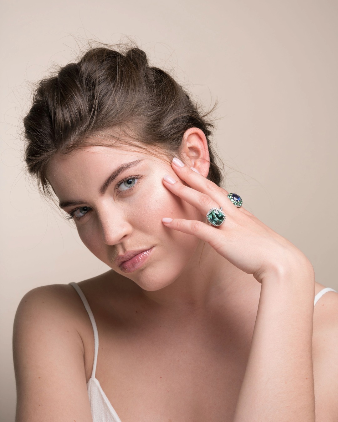 leyser-blue-green-tourmaline-ring-worn-on-hand Model wearing a LEYSER blue-green tourmaline and diamond ring beside her face